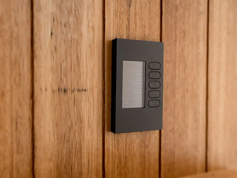 Wall-mounted smart control panel on a wooden wall.