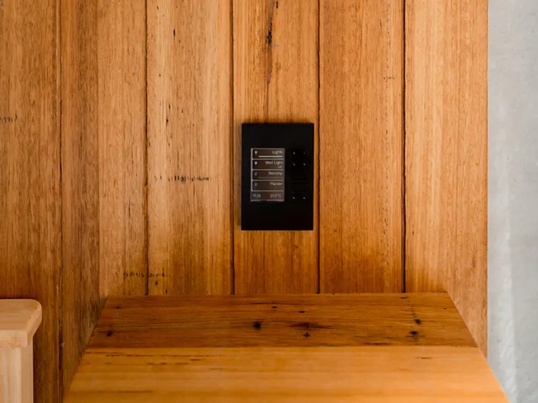 Smart wall control panel on a wooden wall.