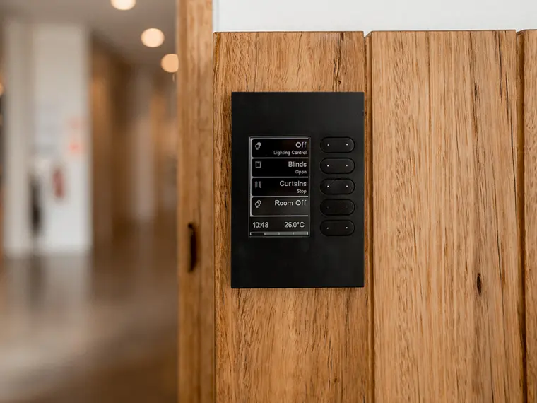 Smart wall control panel on a timber wall.