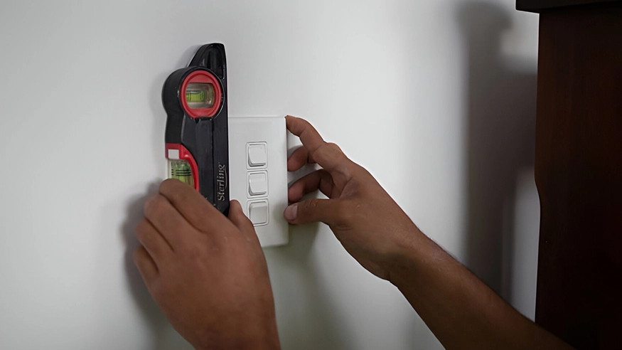 Chris installing an Iconic Styl switch in the Silver swatch on the kitchen wall.
