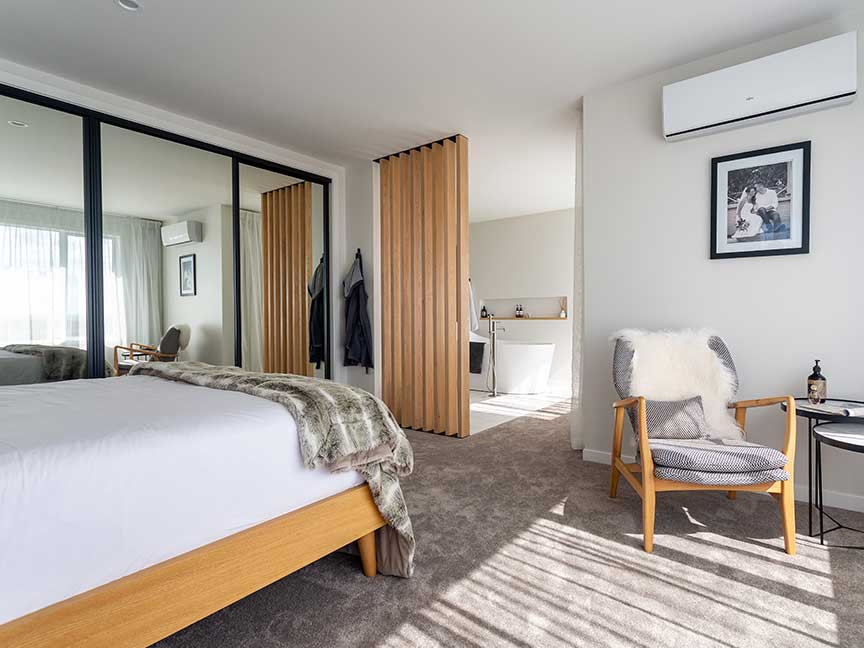 Relaxing bedroom with furniture & mirror.