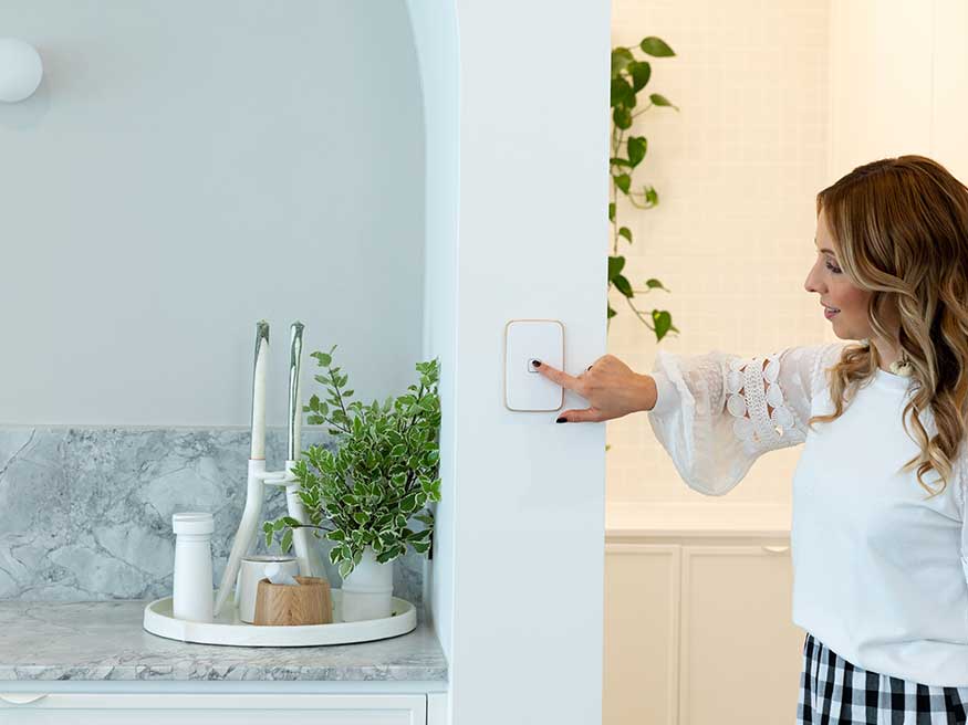 Carmel Siciliano-Klemm presses an Iconic Essence Arctic white light switch.