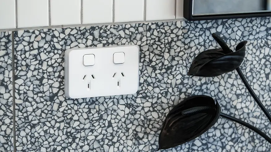 Iconic double power outlet in Vivid White installed on terrazzo backsplash.