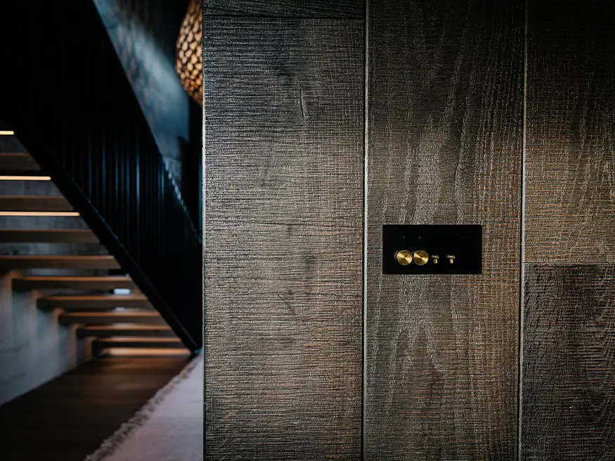 A custom Clipsal Solis Collection switch in Design Builders’ new build, featuring a black plate and brass toggles.