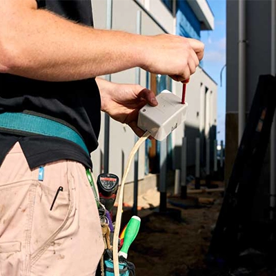 An electrician holding a PDL Junction Box.