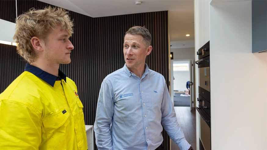 Two electricians from Christchurch Electrical having a conversation.