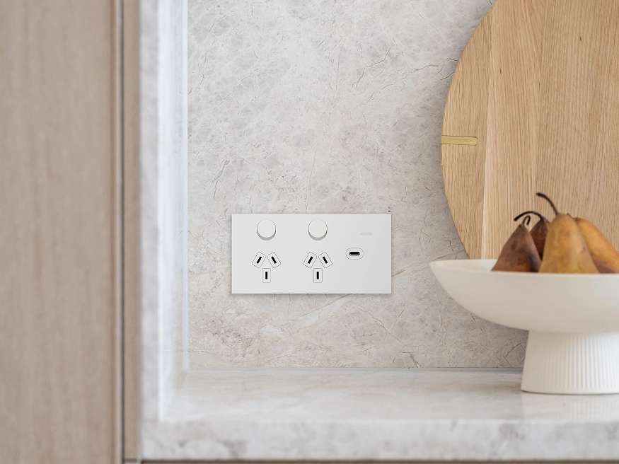 Clipsal Solis switches and power points in a White Ceramic finish mounted on a beige tiled wall.