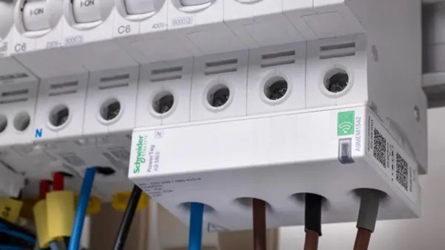 A Schneider Electric PowerTag product installed into a switchboard alongside various circuit protection devices.