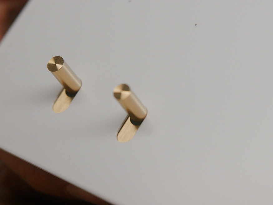 A close up of a Clipsal Solis T Series Ceramic White switch with custom Brass toggle switches.