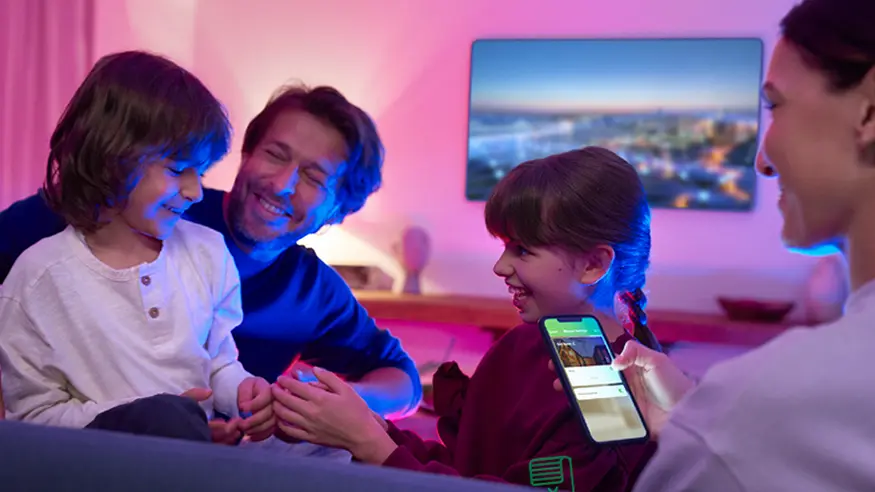 A family of four enjoys a cozy evening in a warmly lit room.