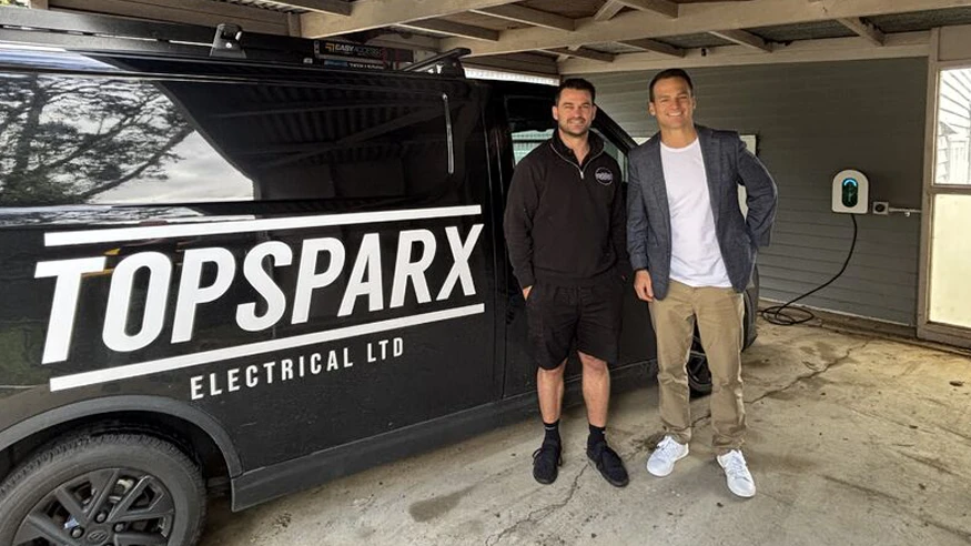 Two electricians from Top Sparx Electrical standing in front of their work truck.
