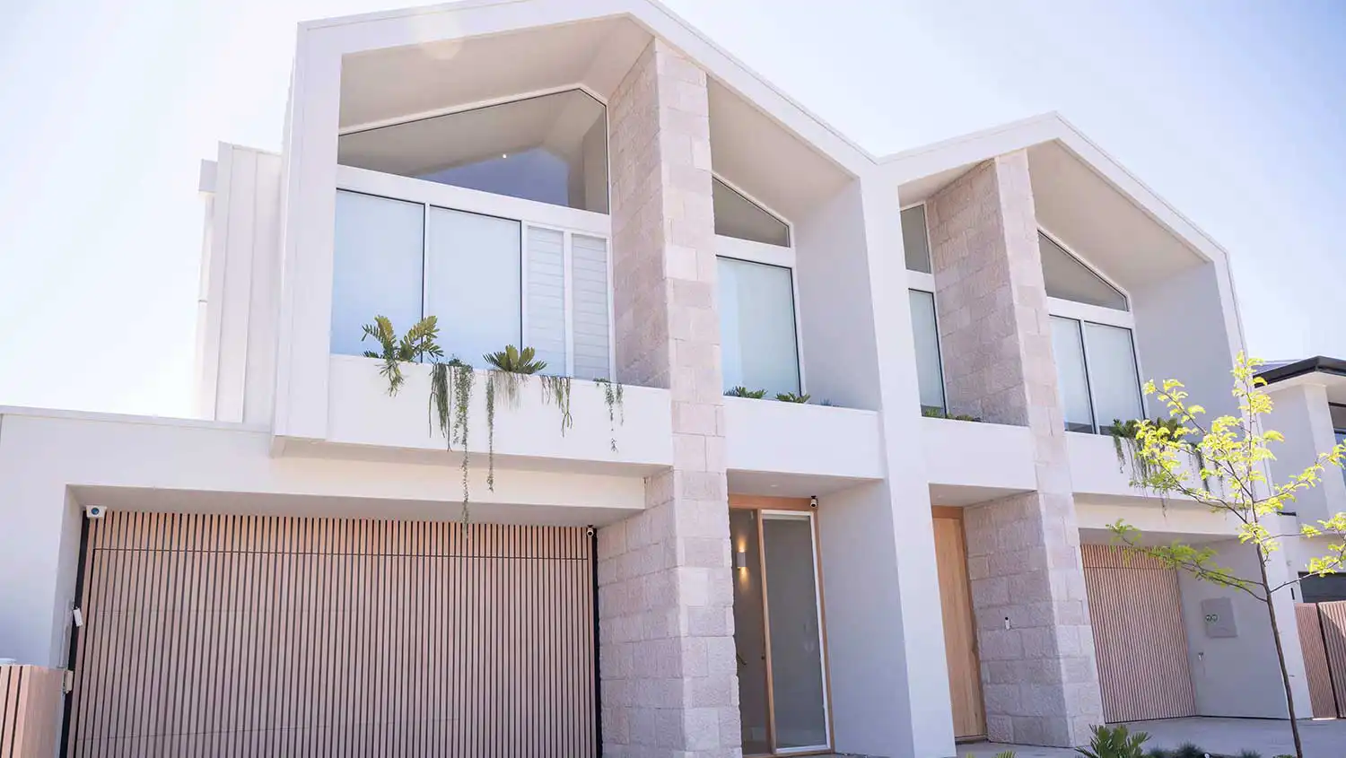 Modern house with two garages and large window.