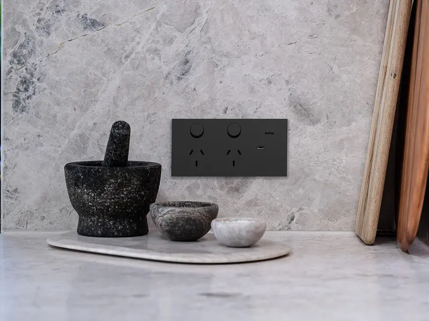 Clipsal Solis Double Switch Power Point with USB-C Charger in Zen Black finish on a marble kitchen wall.