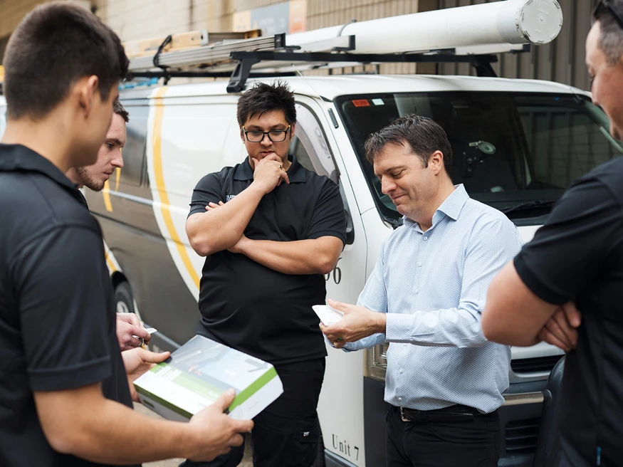 A group of electricians discussing a PDL product package.