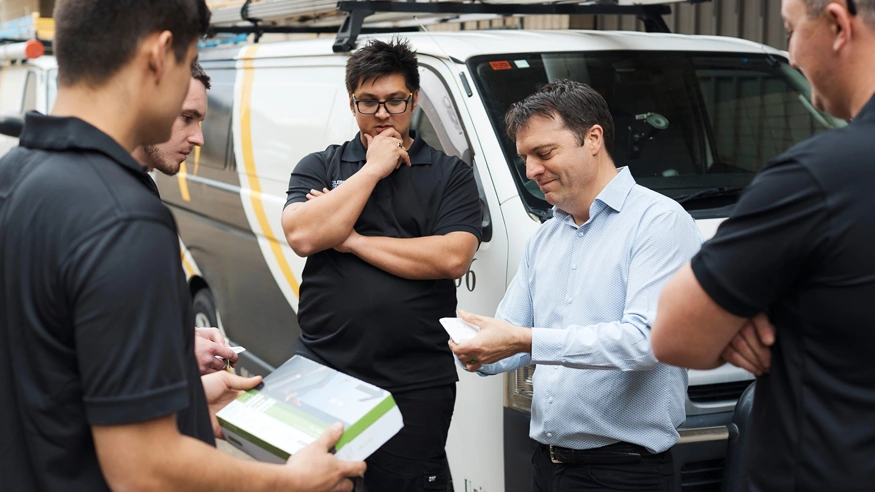 A group of electricians discussing PDL by Schneider Electric products.