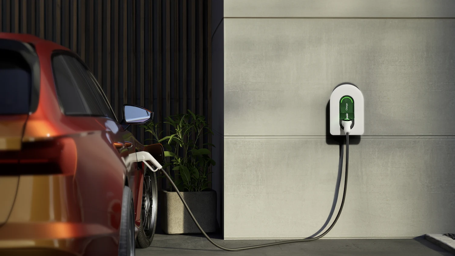 A wall-mounted Schneider Charge charging station being used to charge a red electric vehicle in a residential setting.