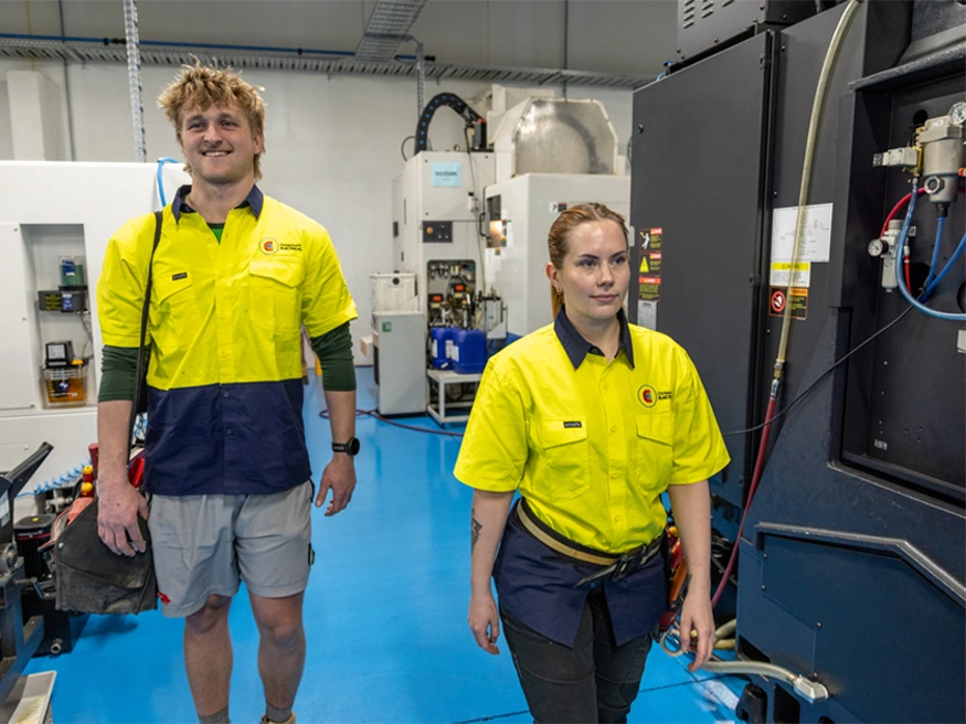 Two staff electricians from Christchurch Electrical walking through a work site.