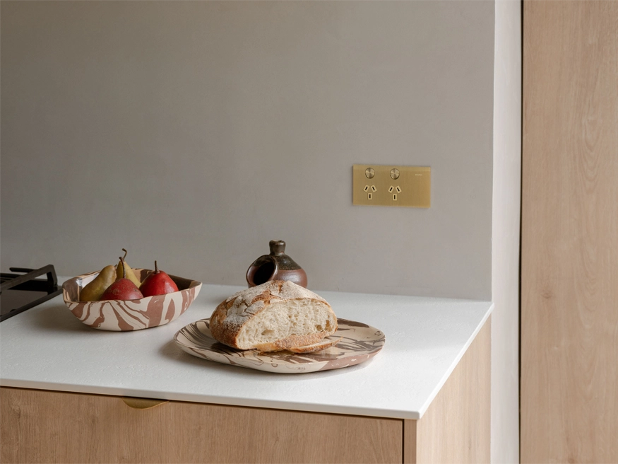A Brushed Brass Clipsal Solis™ Collection power point installed in a kitchen.