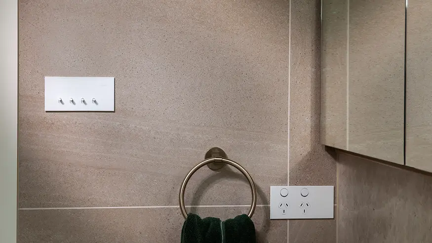 A Clipsal Solis™ white switch and socket installed on a wall.