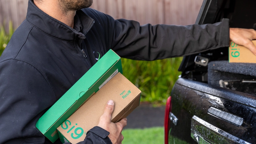 An electrician holding Schneider Electric Resi9 products.