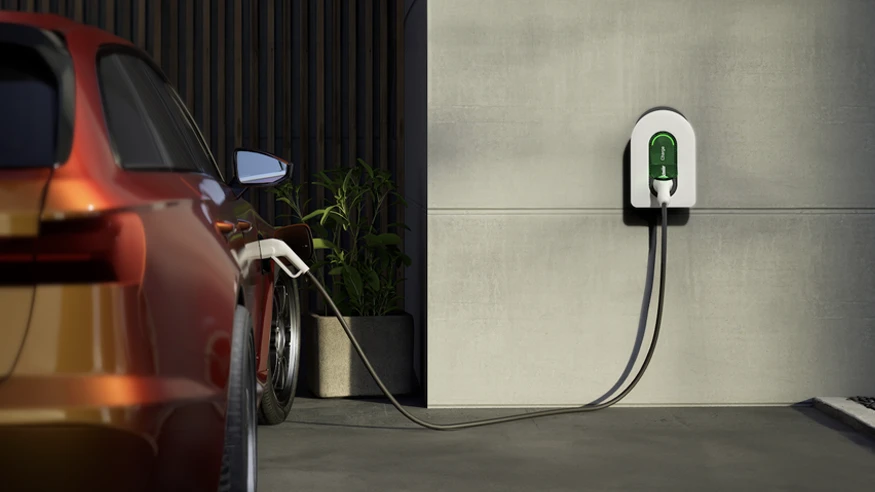 An orange electric car being charged outdoors with a Schneider Electric EV charger.