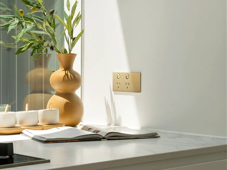 A Clipsal Solis T Series power outlet in brushed brass.