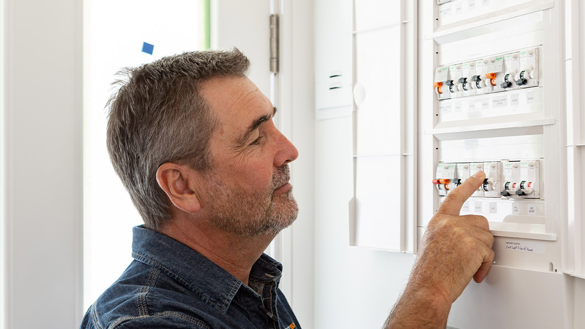 Builder Peter Wolfkamp inspecting an arc fault detection device (AFDD) in his home’s switchboard post-renovation.