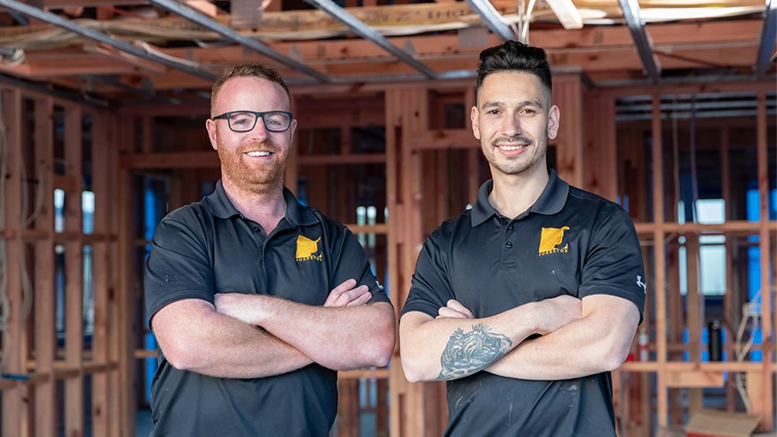 Nathan from Johnston Electrical Services and a fellow electrician smiling at a camera.