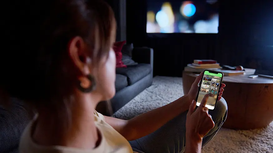 A homeowner uses the Wiser by SE app on her phone.