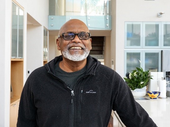 Des Dass smiling in his home.