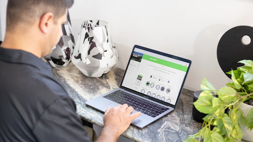An electrician reviewing Wiser Smart Home training modules on his laptop.