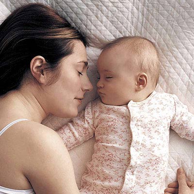 Mum and baby sleeping on bed