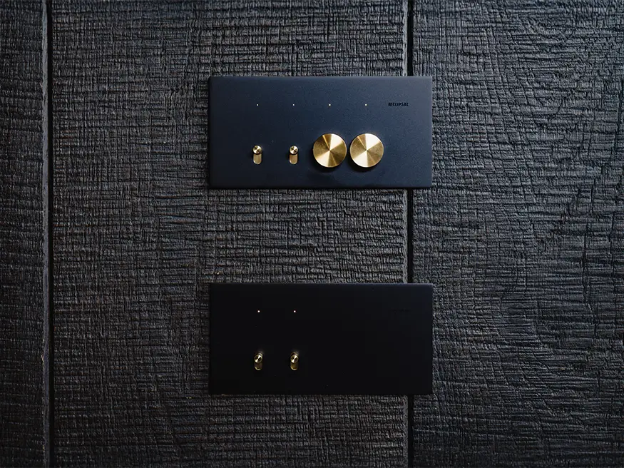 Black Solis switches with custom brass toggles and dimmers.
