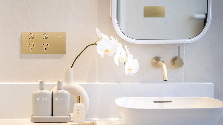 Modern bathroom with Solis switches and power points, gold fixtures, and orchid.