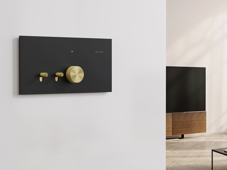 Clipsal Solis T Series switch with rotary adaptor on a white wall in a modern living room.